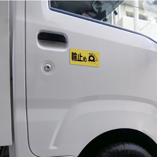 運転席側ドアに貼ることで輪留め確認を促します。